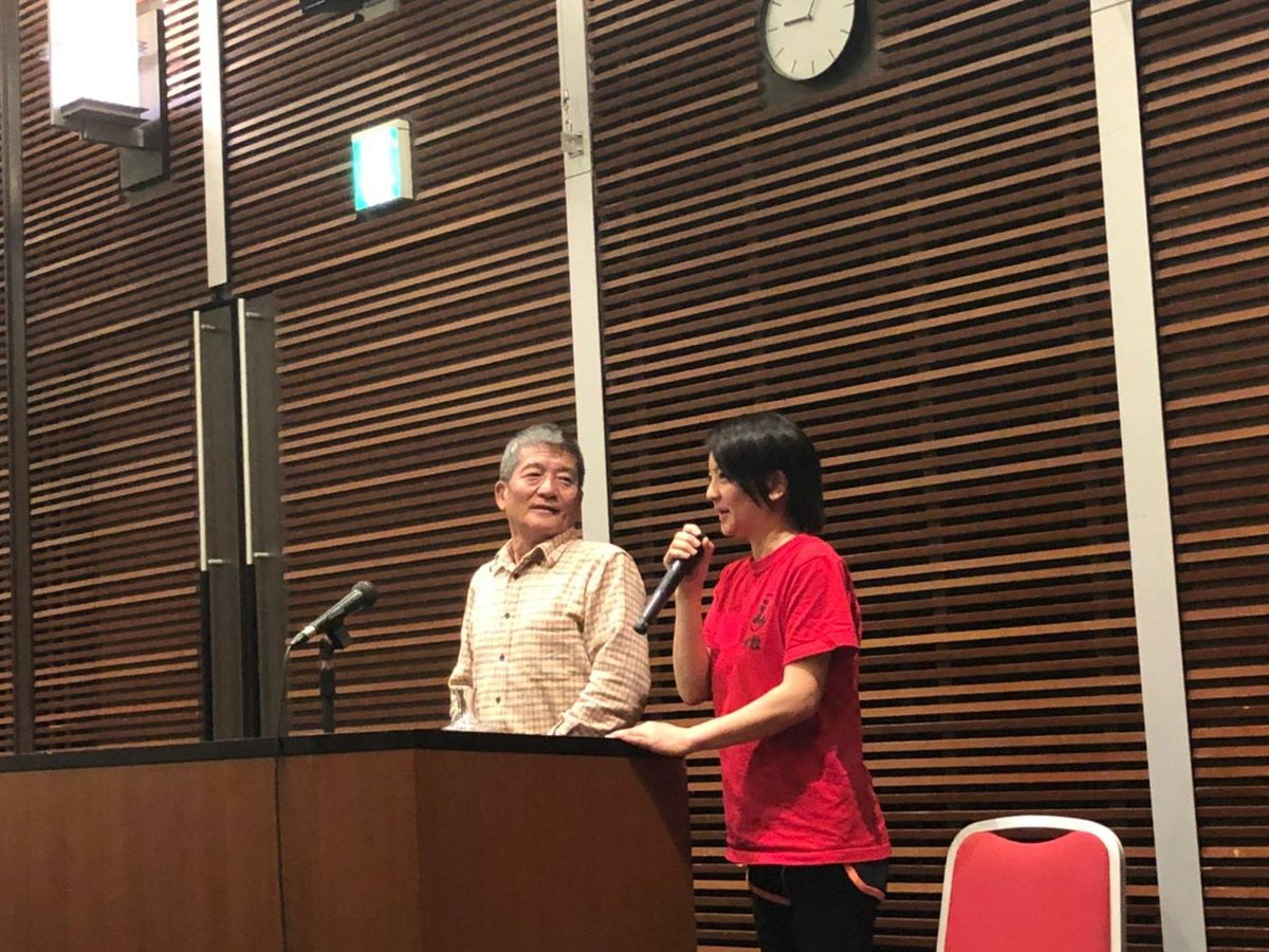 地域の講演会に登壇する、創業者である父（左）と、二代目のエリ（右）